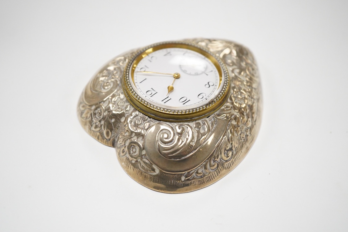A late Victorian repousse silver mounted brass heart shaped bedside timepiece, with Arabic dial and subsidiary seconds, Douglas Clock Co. Birmingham, 1900, 94mm.